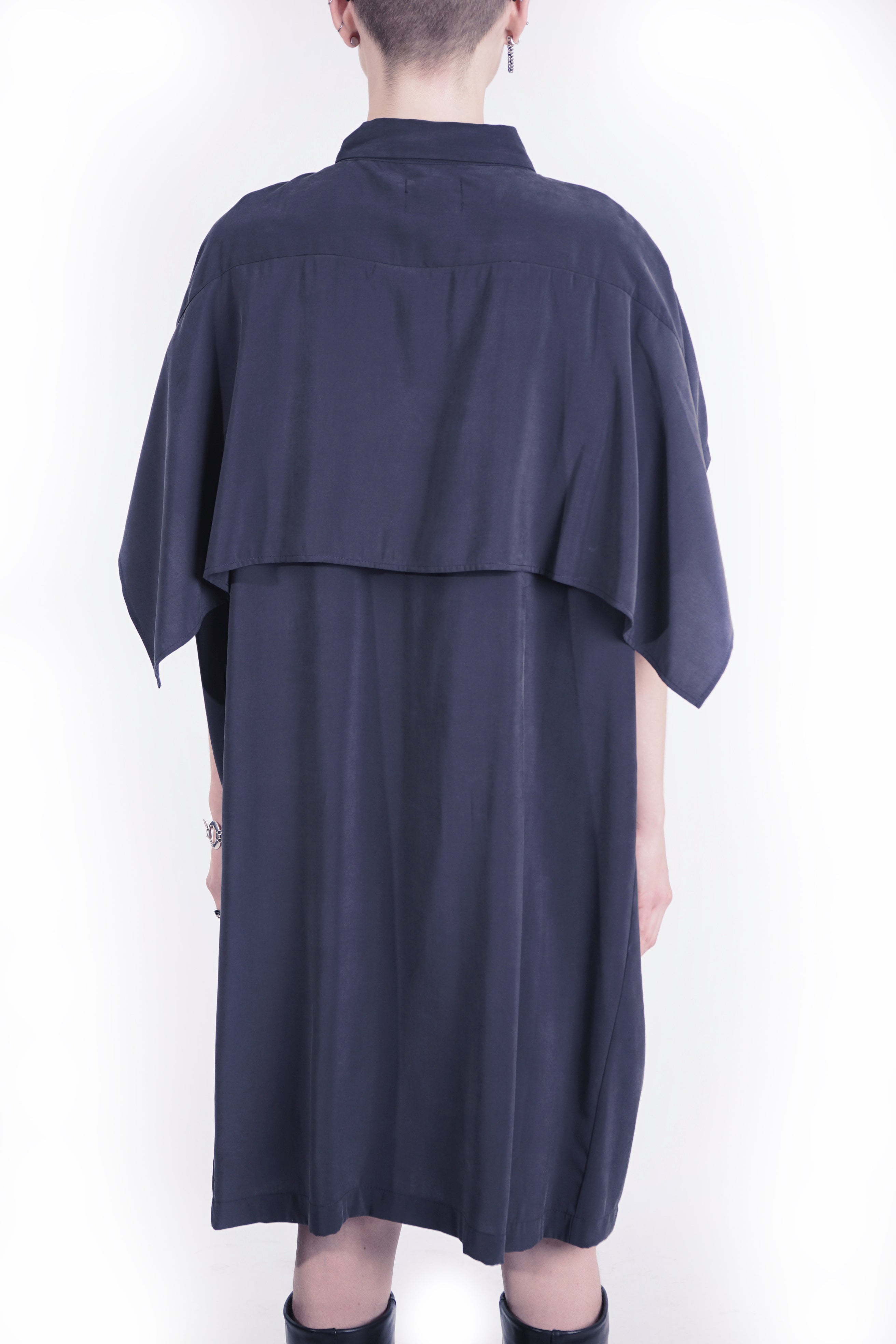 Side view of sleeveless draped black dress